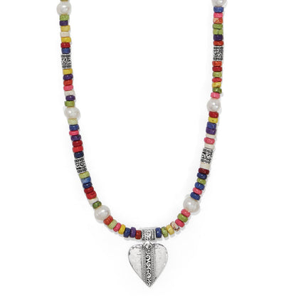 Brighton beaded necklace with multicolored heishi beads, potato pearls, silver-plated accents, and heart pendant on a white background