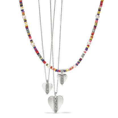 Brighton layered necklaces with silver-plated hammered heart pendants, colorful heishi beads, and potato pearls on a white background