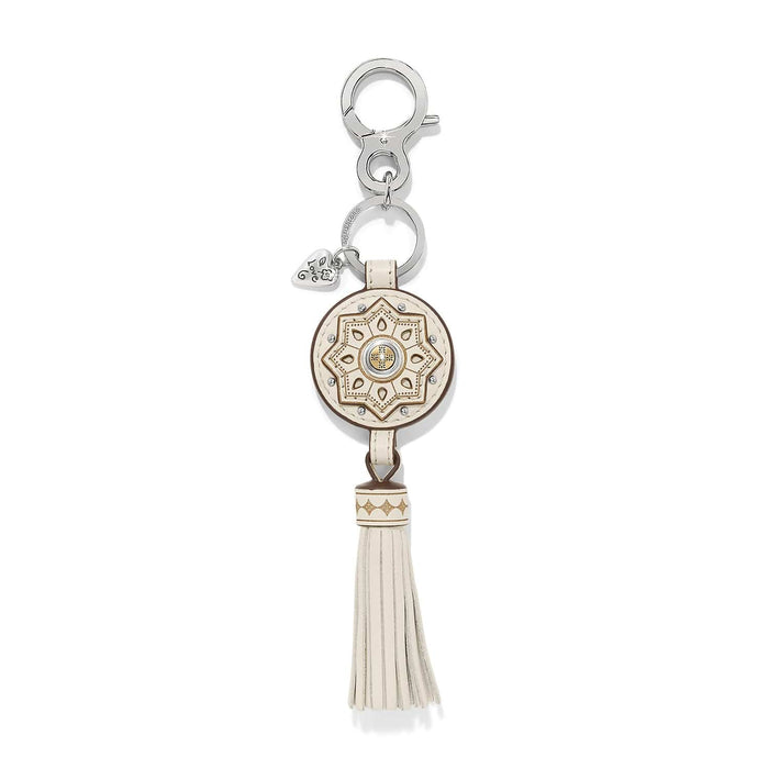Brighton key fob with cream leather medallion, gold star pattern, tassel, and silver-tone clasp on a white background