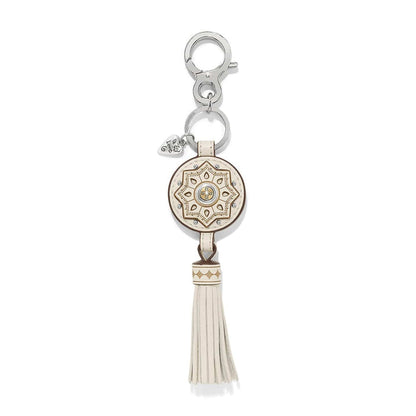 Brighton key fob with cream leather medallion, gold star pattern, tassel, and silver-tone clasp on a white background