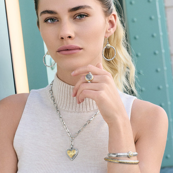 Model wearing Brighton two-tone hoop earrings with matching pendant necklace, ring, and coordinating Brighton accessories