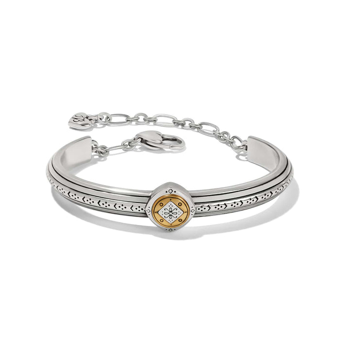 Brighton two-tone cuff bracelet with silver band, etched detailing, gold medallion center, and chain closure on a white background