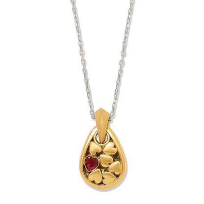 Brighton pendant necklace with two-tone teardrop charm, heart details, red crystal accent, and silver chain on a white background