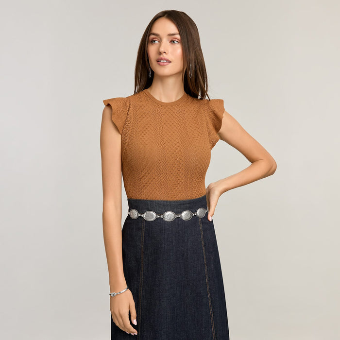 Model wearing a Brighton silver-tone concho chain belt with oval medallions over a dark denim skirt