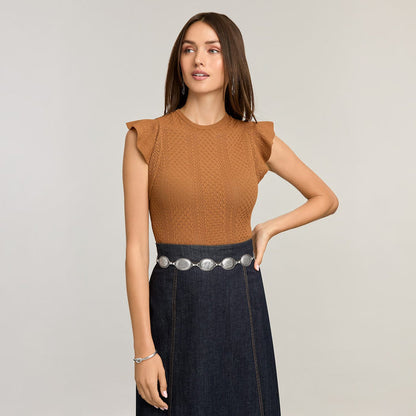 Model wearing a Brighton silver-tone concho chain belt with oval medallions over a dark denim skirt