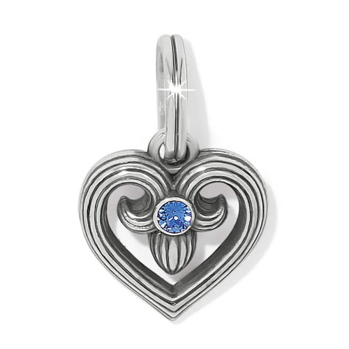 Brighton heart charm with scrolled silver-plated design and blue crystal center on a white background