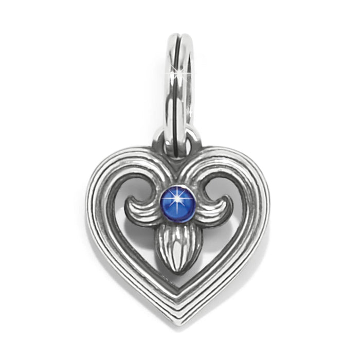 Brighton heart charm with silver-plated scrollwork design and blue crystal center accent on a white background