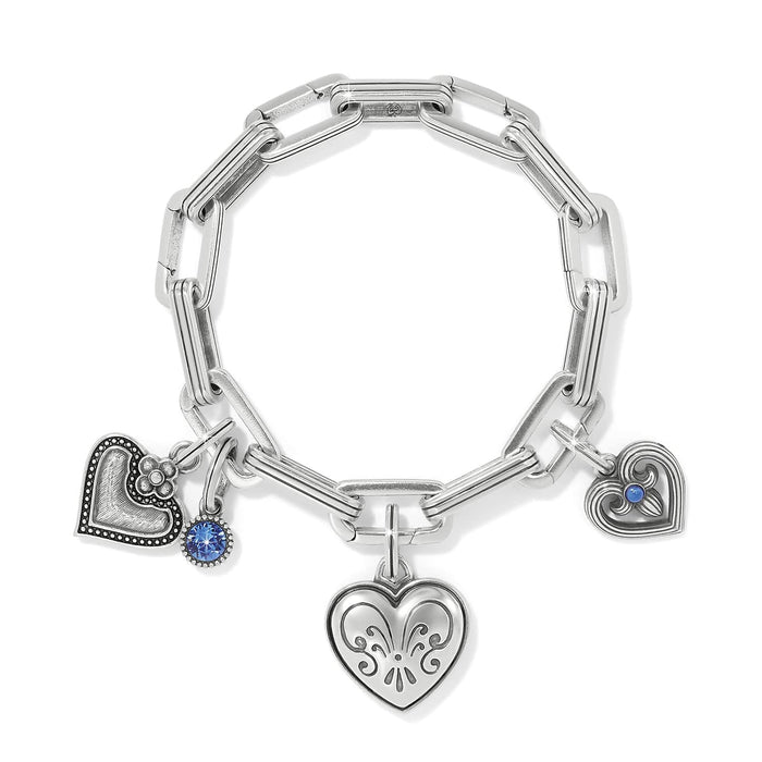 Brighton silver-plated charm bracelet with heart charms, blue crystal accent, and paperclip chain links on a white background