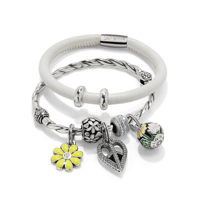 Brighton silver-plated charm bracelets with white leather band, floral charms, crystal heart, and yellow daisy on white background
