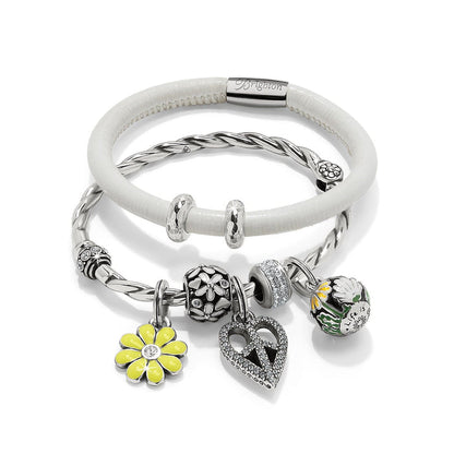 Brighton silver-plated charm bracelets with white leather band, floral charms, crystal heart, and yellow daisy on white background