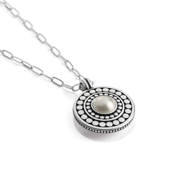 Brighton pendant necklace with glass pearl cabochon center, two-tone beaded medallion, and paperclip chain on a white background