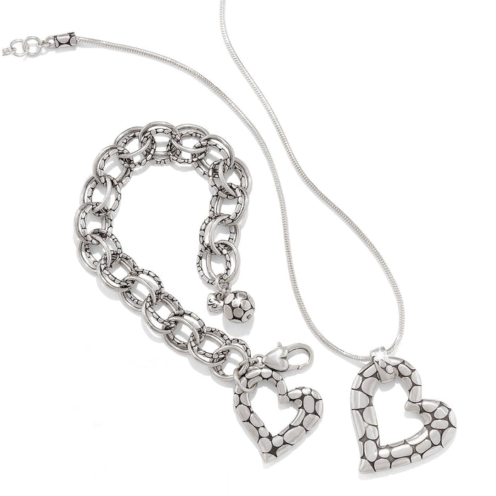 Brighton silver-plated heart pendant necklace styled with a matching link bracelet featuring pebbled texture on white