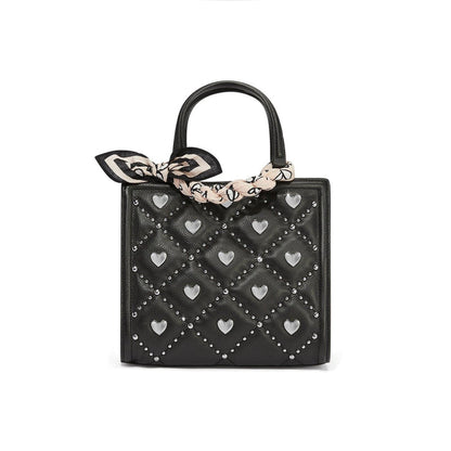 Brighton black quilted handbag with silver-tone heart studs and patterned scarf tied around handle on a white background