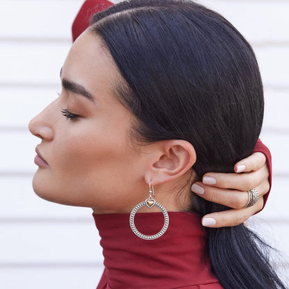 Model wearing a Brighton two-tone drop earring with beaded silver hoop and gold heart accent