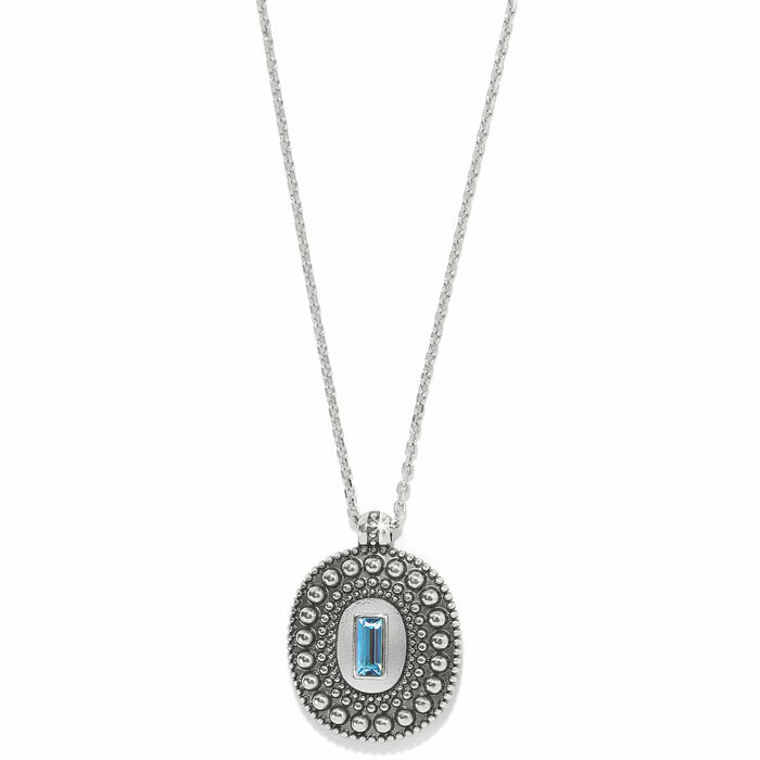 Brighton pendant necklace with silver-plated beaded oval medallion and blue crystal baguette center on a white background