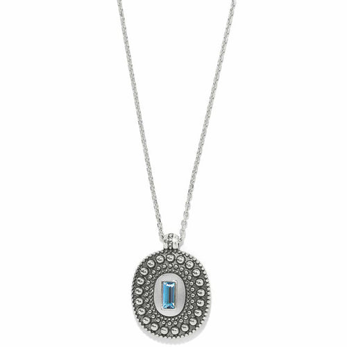 Brighton pendant necklace with silver-plated beaded oval medallion and blue crystal baguette center on a white background