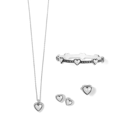 Brighton heart pendant necklace, hinged bangle bracelet, and stud earrings set with silver-plated finish on a white background