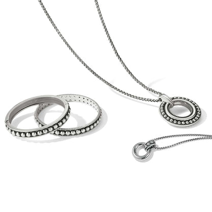 Brighton silver-plated pendant necklace styled with beaded bangle bracelets on a white background