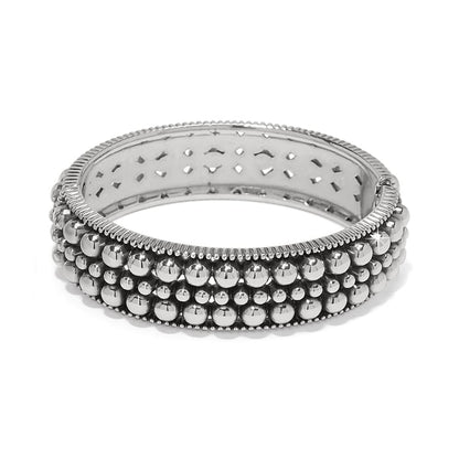 Brighton hinged bangle bracelet with three rows of silver-plated beads and ribbed edges on a white background