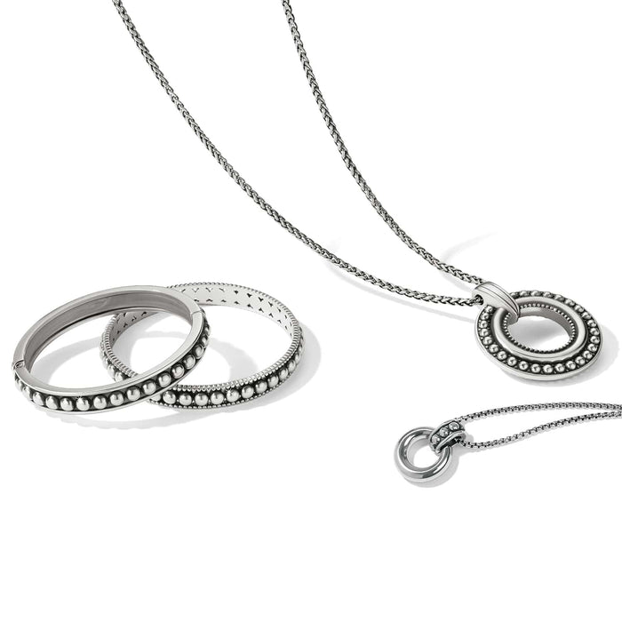 Brighton silver-plated jewelry set styled with beaded bangles and circle pendant necklaces on a white background