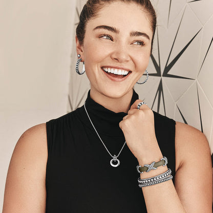Model wearing a Brighton silver-plated pendant necklace with coordinating Brighton hoop earrings, bracelets, and ring