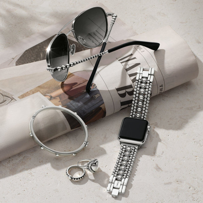 Brighton silver-plated watch band with beaded links styled with sunglasses and other accessories on a newspaper backdrop