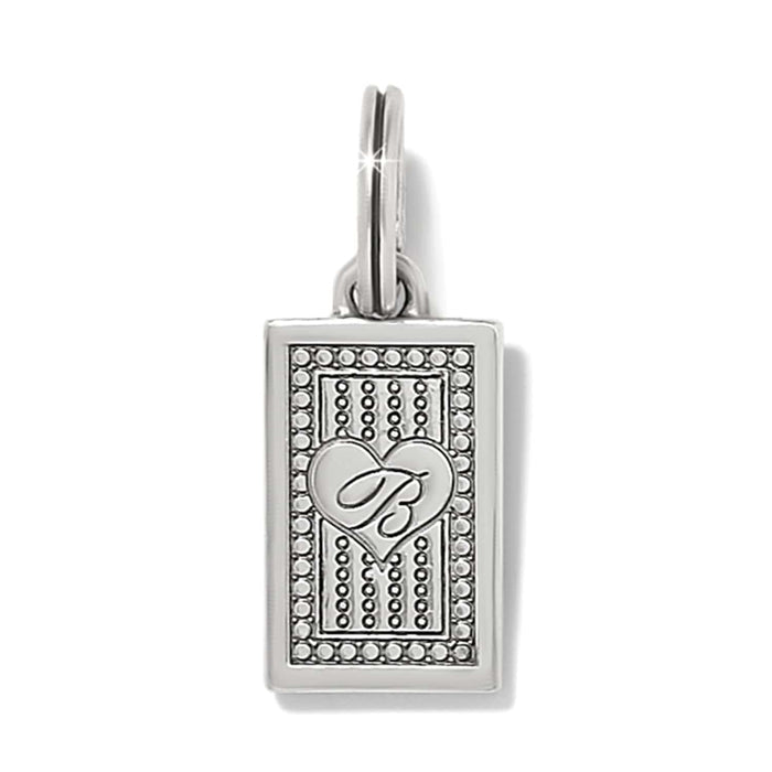 Brighton rectangular charm with silver-plated heart and scripted B emblem over beaded pattern on a white background