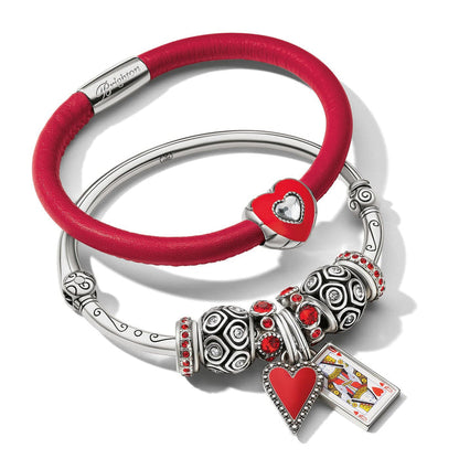 Brighton bracelets in red leather and silver-plated bangle with heart charms, red crystals, and playing card charm on white background