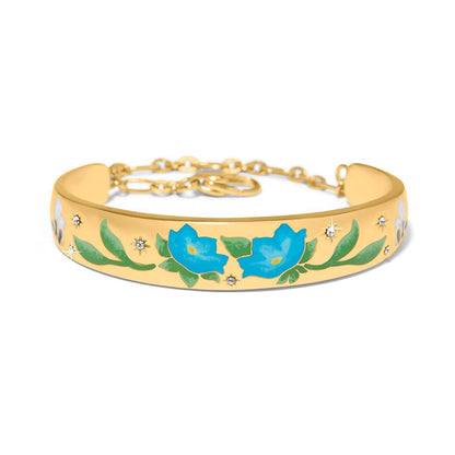 Brighton gold-plated cuff bracelet with blue enamel flowers, green leaves, and crystal star accents on a white background