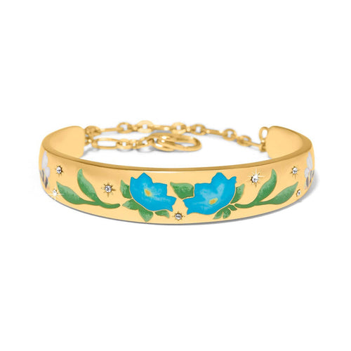 Brighton gold-plated cuff bracelet with blue enamel flowers, green leaves, and crystal star accents on a white background