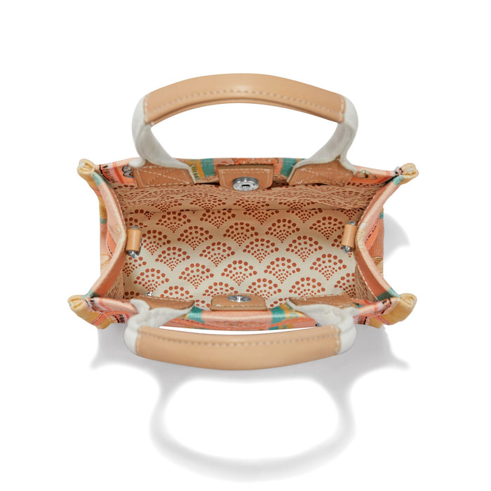 Brighton handbag interior view with patterned fabric lining, tan leather handles, and silver-tone snap closure on a white background