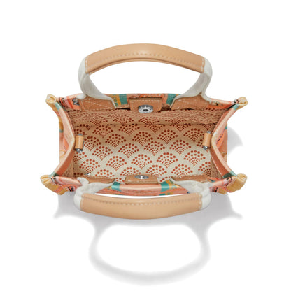 Brighton handbag interior view with patterned fabric lining, tan leather handles, and silver-tone snap closure on a white background