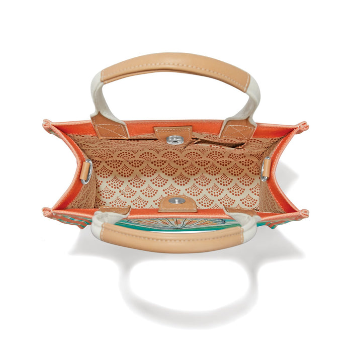 Brighton handbag interior view showing orange lining, patterned inner pocket, tan handles, and magnetic closure on a white background