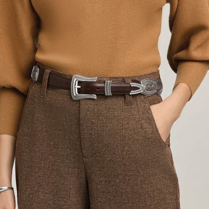 Model wearing a Brighton brown leather belt with ornate silver-tone engraved buckle, keeper, and tip