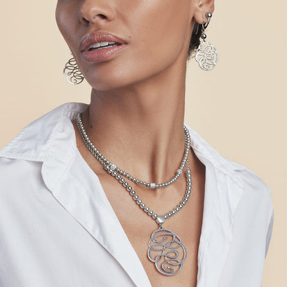 Model wearing a Brighton silver-plated beaded necklace with hammered swirl pendant paired with matching drop earrings
