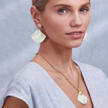 Model wearing Brighton gold-plated shell drop earrings paired with a matching shell pendant necklace on gold chain