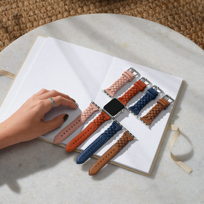 Brighton braided leather watch bands in pink, orange, navy, and tan with silver-plated buckles styled on a journal