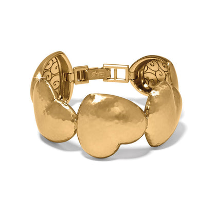 Brighton bracelet with hammered gold-plated heart-shaped links and decorative scrollwork clasp on a white background
