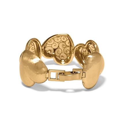 Brighton heart link bracelet with gold-plated finish, scrollwork interior detail, and hinged clasp on a white background