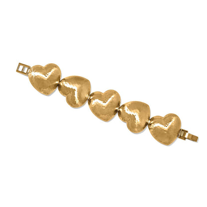 Brighton bracelet with five gold-plated hammered heart-shaped links and fold-over clasp on a white background