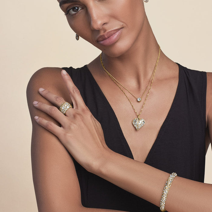 Model wearing a Brighton gold-plated heart pendant necklace with crystals and coordinating Brighton accessories