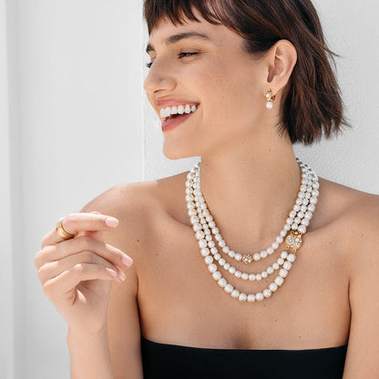 Model wearing a Brighton triple-strand pearl necklace with gold-plated crystal accents paired with matching drop earrings