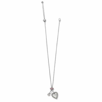 Brighton silver-plated necklace with hammered heart pendant, crystal charm, and pink crystal accent on a white background