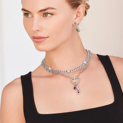 Model wearing layered Brighton silver-plated chain necklaces with heart stations, red crystal charm, and coordinating Brighton accessories